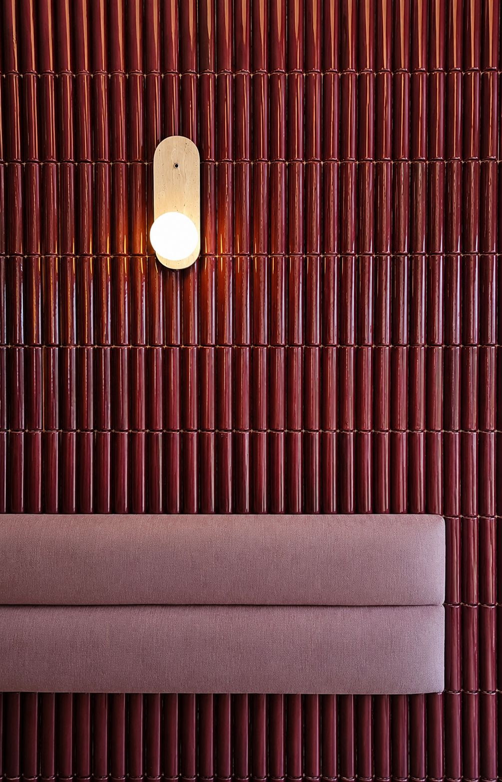 Mur de céramique bambou bordeaux et banquette rose